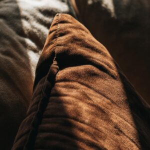 Close-up of cozy brown and beige cushions with soft, warm lighting, creating a relaxing ambiance.