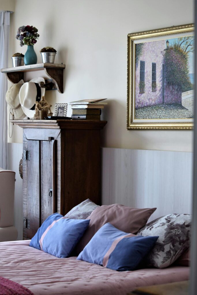 Inviting bedroom interior featuring pink bedspread and blue pillows.